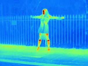 Woman standing against fence: thermal photography